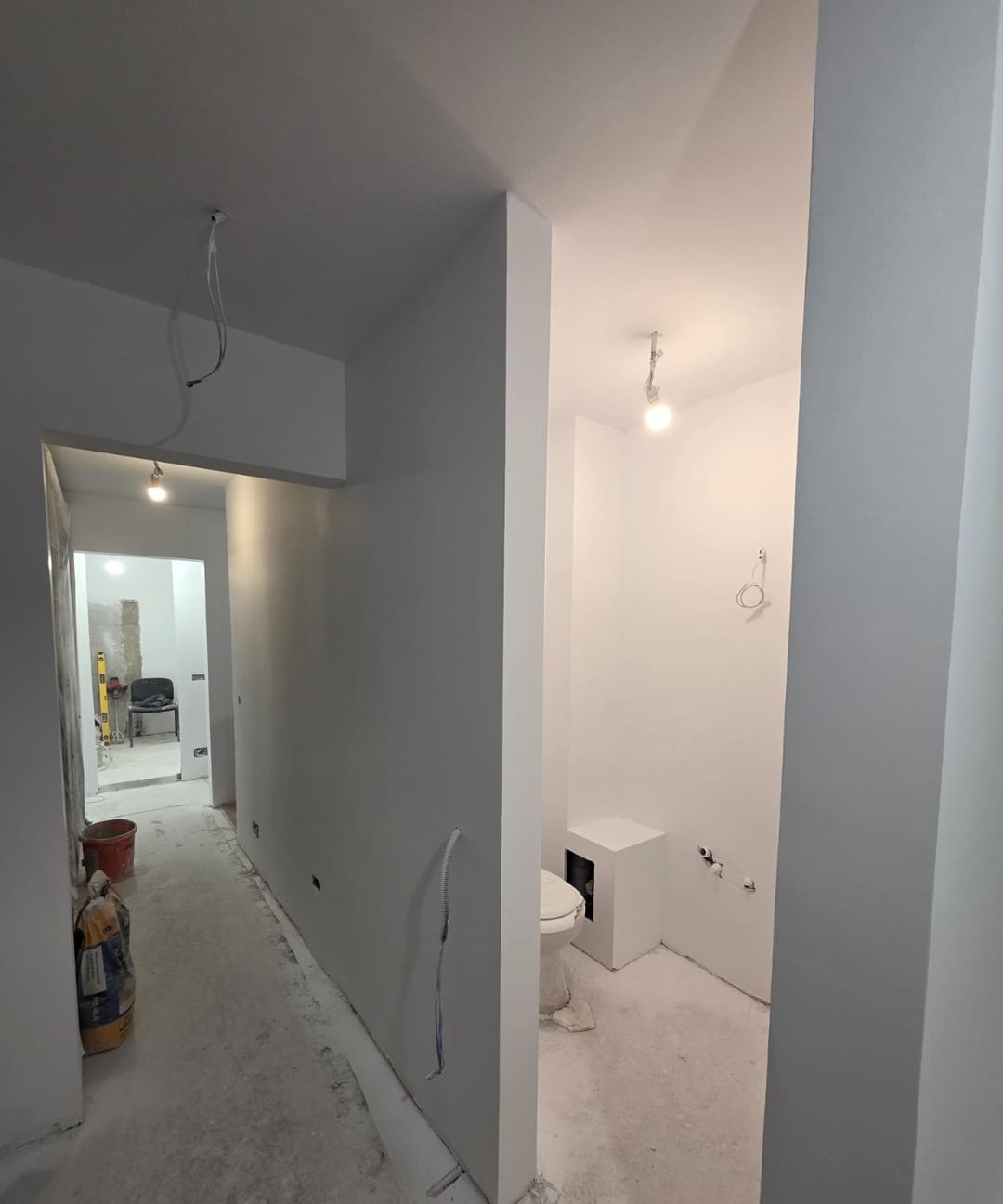 Aceeași baie după finisare: caseta gletuită și vopsită în alb, pereți finisați