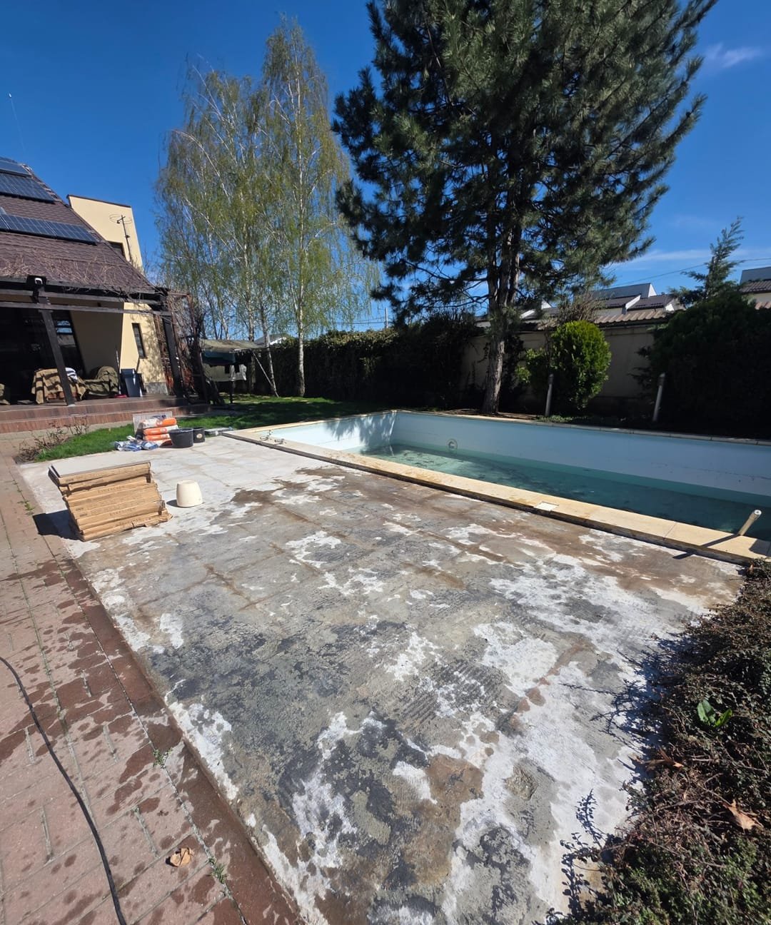 Terasă de piscină înainte de renovare: placă de beton degradată, urme de mortar, fără finisaj